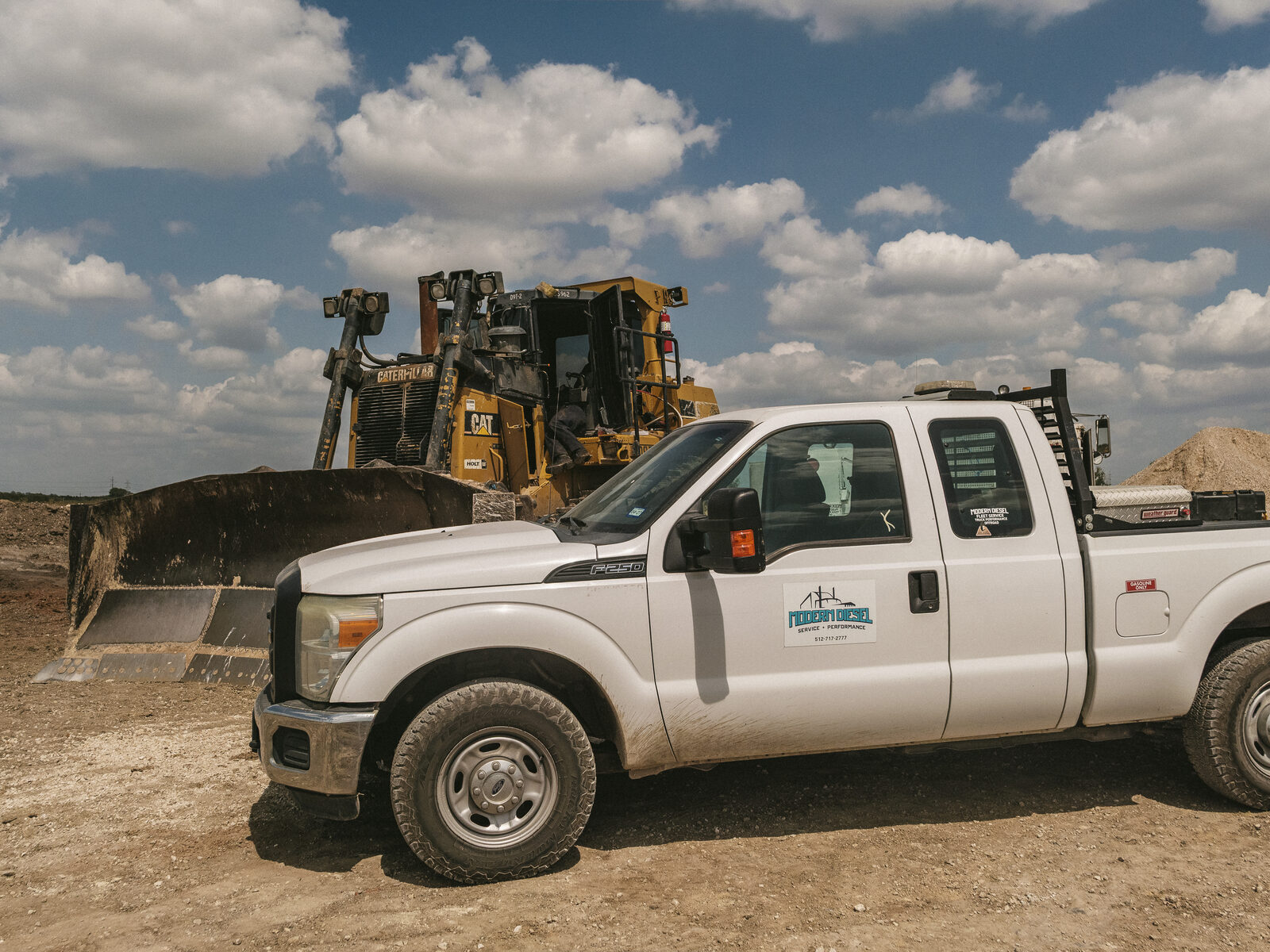 Modern Diesel service truck pulled up beside a Cat D9 dozer on a job site