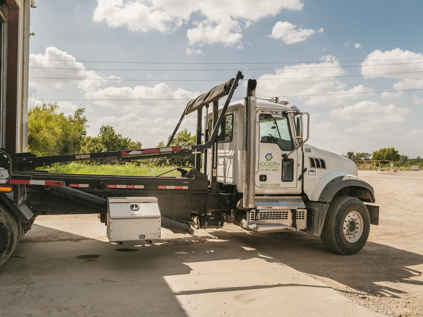 Mack hooklift truck parked outside the bay door