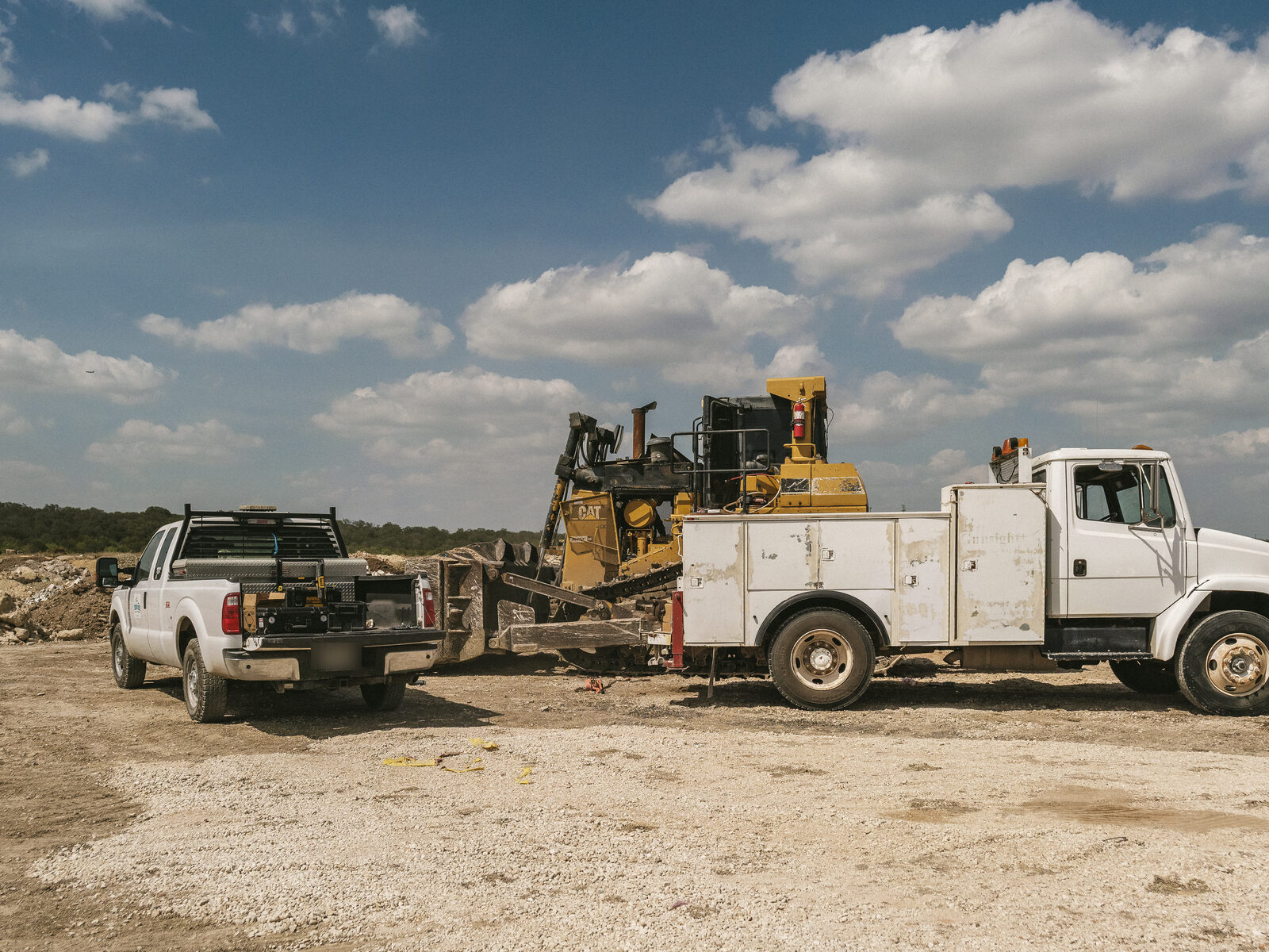 Service truck, pickup, and a Cat dozer on a customer job site
