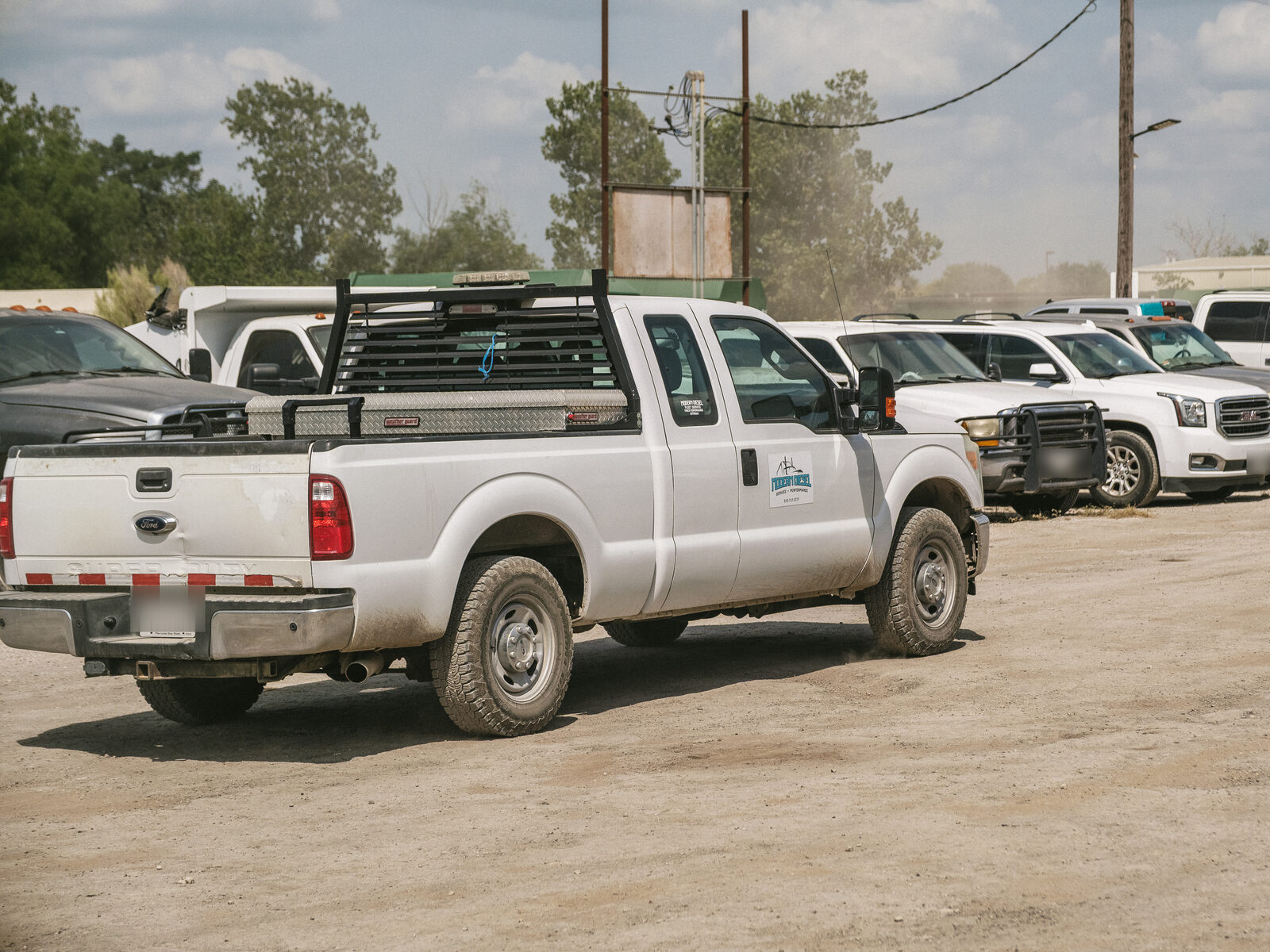 Modern Diesel service truck parked in a customer's yard with their fleet lined up behind it