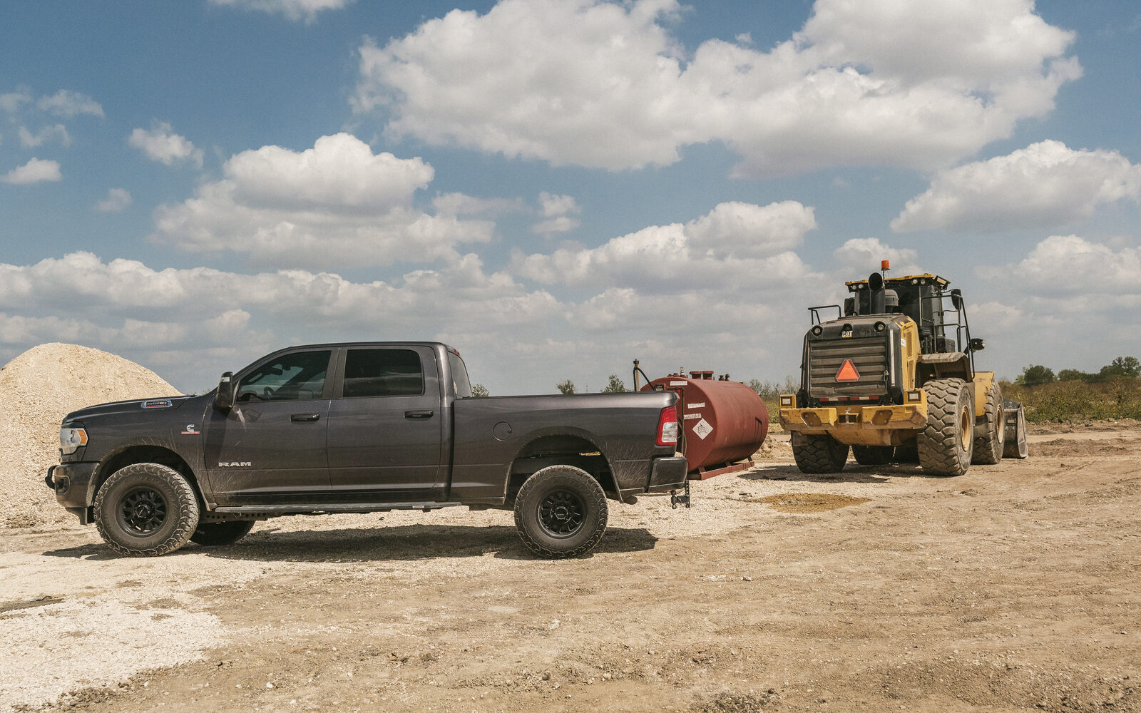 Current-generation Ram 2500 Cummins with a bed-mounted transfer tank on a job site