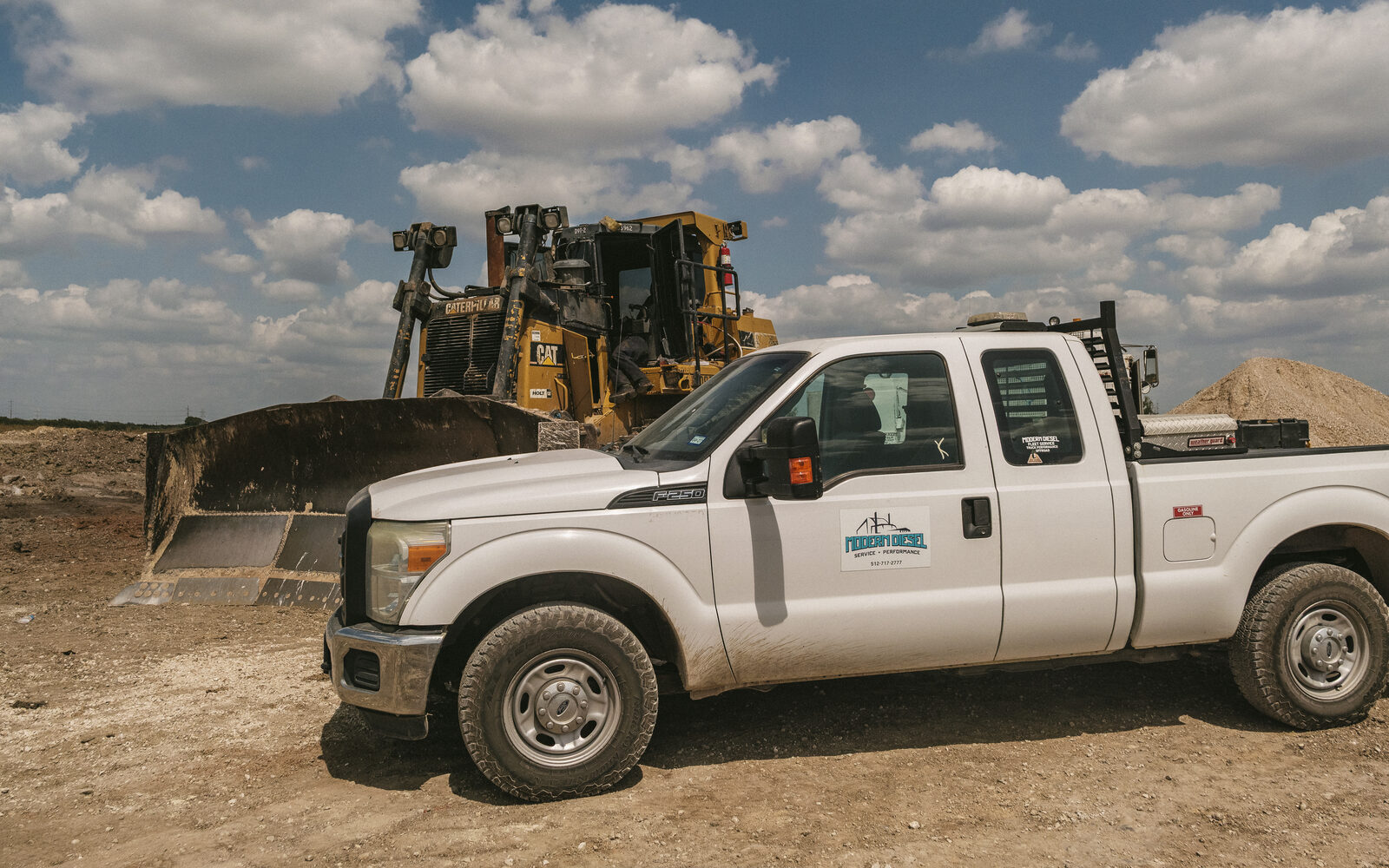 Modern Diesel service truck pulled up beside a Cat D9 dozer on a job site