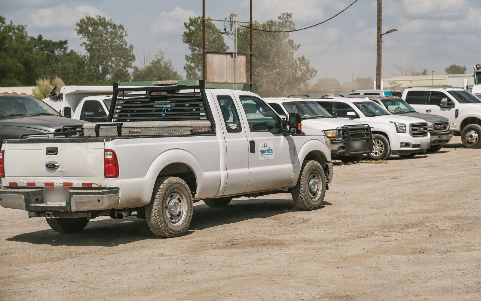 Modern Diesel service truck parked in a customer's yard with their fleet lined up behind it